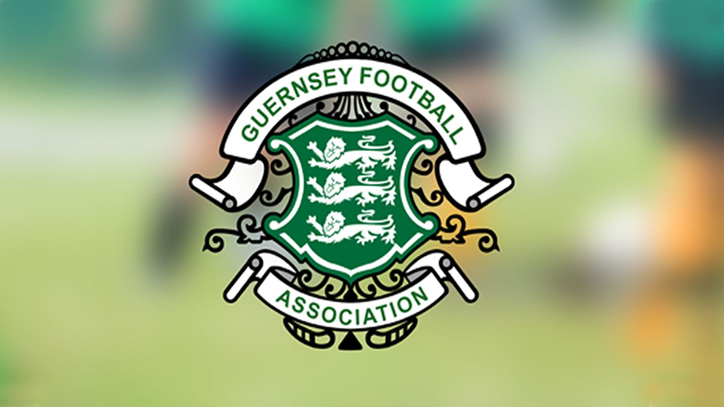 Logo of the Guernsey Football Association, featuring three lions on a green shield with decorative elements.